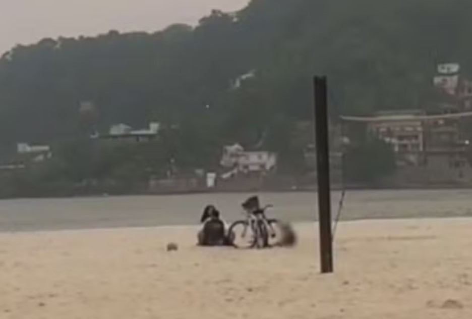 Casal gera revolta ao ser flagrado fazendo sexo ao lado de criança na praia.